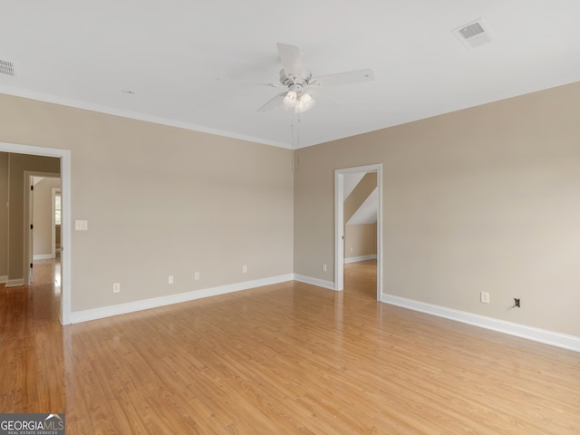 empty room with light wood-style floors, baseboards, ornamental molding, and a ceiling fan