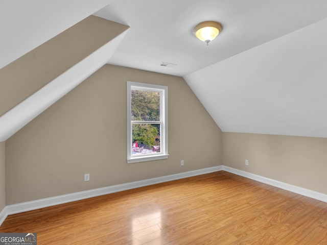bonus room with light wood-style floors, baseboards, and lofted ceiling