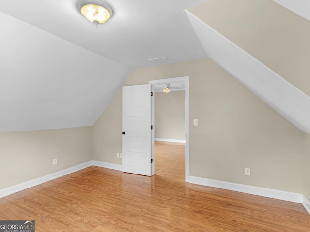 bonus room featuring baseboards, wood finished floors, and vaulted ceiling