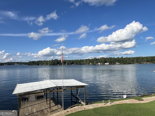 view of dock with a water view and a forest view