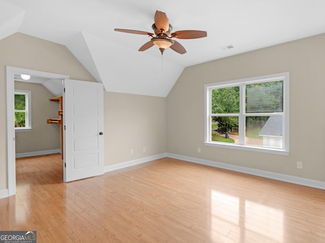 additional living space with visible vents, light wood-style floors, ceiling fan, and vaulted ceiling