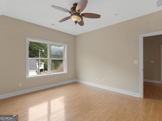 unfurnished room featuring visible vents, a ceiling fan, light wood finished floors, and baseboards