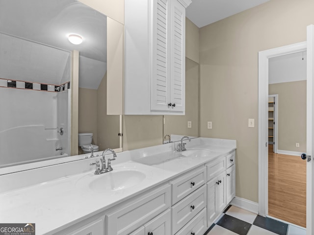 bathroom featuring vanity, vaulted ceiling, and toilet