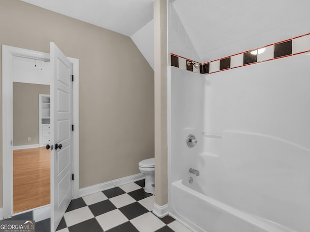 bathroom with toilet, shower / bath combination, and vaulted ceiling