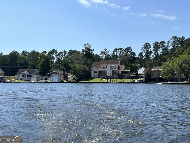 view of dock featuring a lawn and a water view