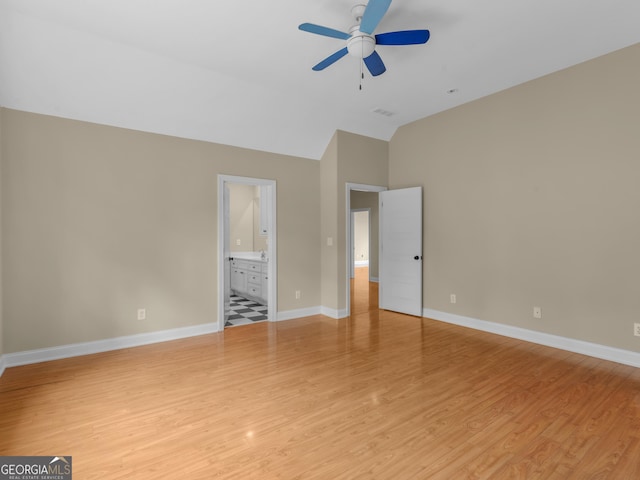 unfurnished bedroom featuring lofted ceiling, baseboards, and light wood finished floors