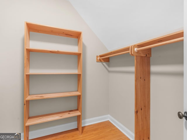 walk in closet with vaulted ceiling and wood finished floors
