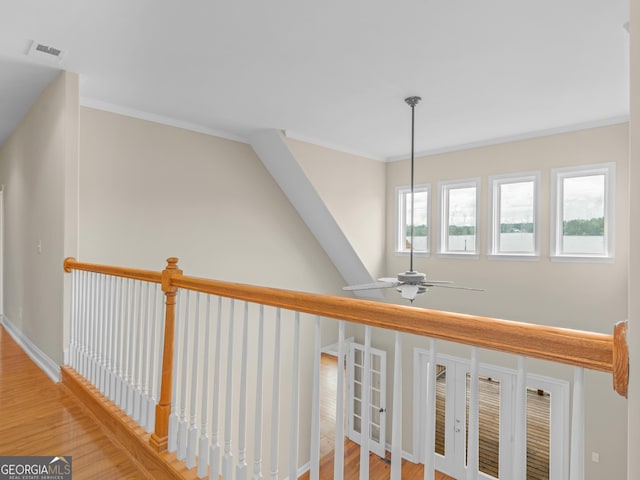 hall with ornamental molding and light hardwood / wood-style floors