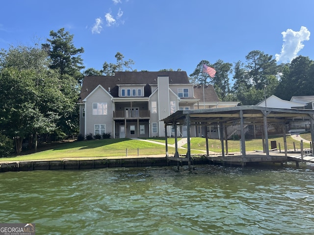 dock area featuring a water view, a balcony, and a yard