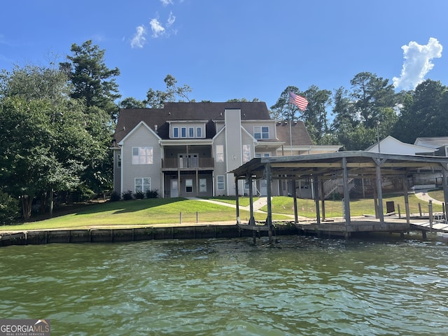 dock area featuring a lawn, a water view, and a balcony