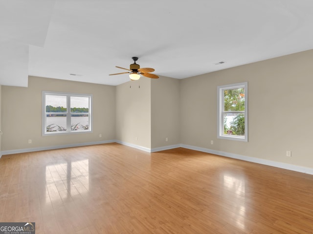 empty room featuring ceiling fan, light hardwood / wood-style flooring, and a healthy amount of sunlight