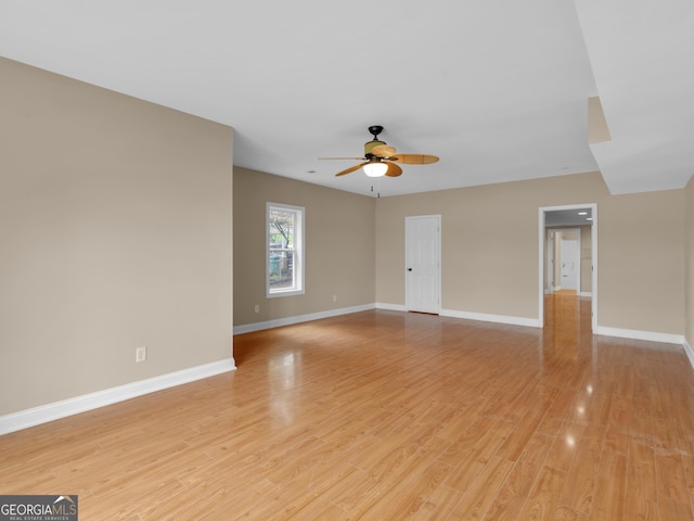 unfurnished living room featuring light wood-style floors, baseboards, and ceiling fan