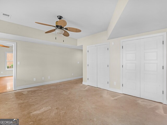 unfurnished bedroom featuring multiple closets and ceiling fan