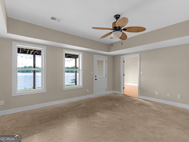 empty room featuring ceiling fan and a water view