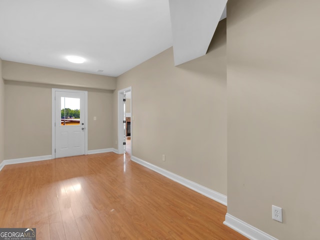 foyer entrance featuring baseboards and light wood finished floors