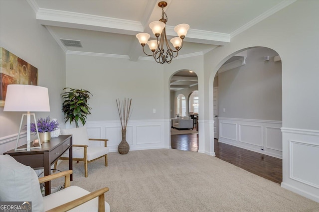 living area with ornamental molding, beam ceiling, carpet floors, and a notable chandelier