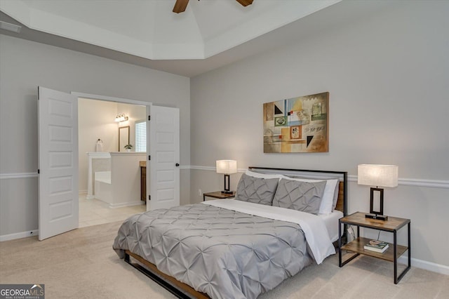 carpeted bedroom with ensuite bath and ceiling fan