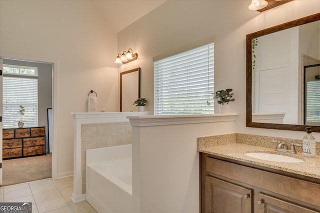 bathroom with vanity, a healthy amount of sunlight, tile patterned floors, and a bathtub