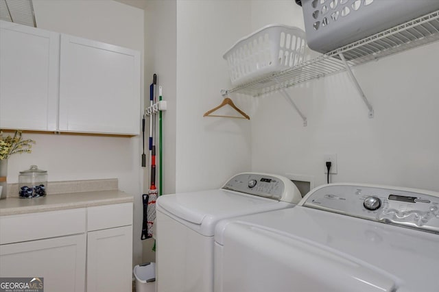 laundry room featuring cabinets and washer and clothes dryer