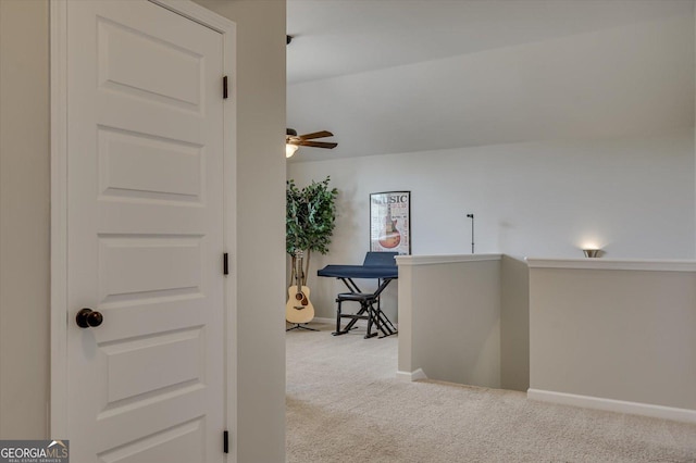 hallway with light carpet and vaulted ceiling