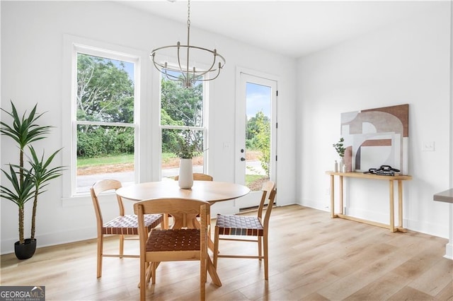 dining space featuring an inviting chandelier and light hardwood / wood-style flooring