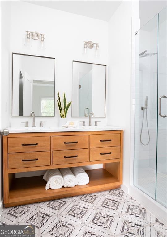 bathroom featuring walk in shower, tile patterned floors, and double sink vanity