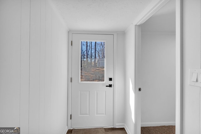 entryway with carpet flooring and a textured ceiling