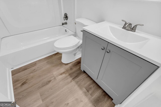 full bathroom with vanity, toilet, shower / bathing tub combination, and hardwood / wood-style flooring