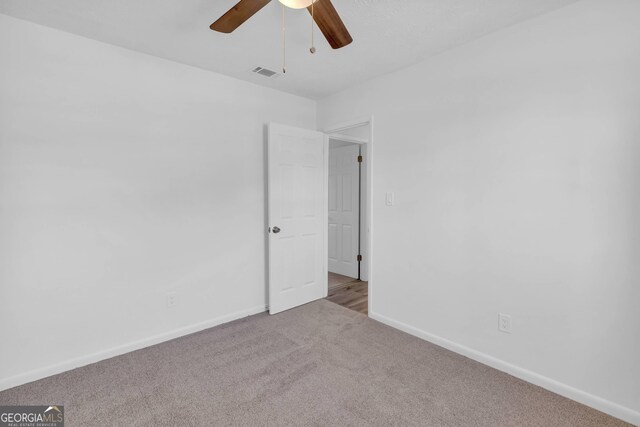 carpeted empty room featuring ceiling fan