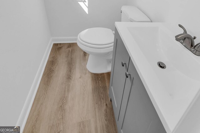 bathroom featuring vanity, hardwood / wood-style flooring, and toilet