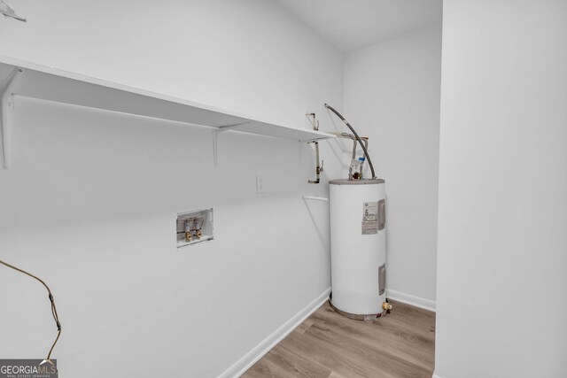 washroom with hardwood / wood-style flooring, washer hookup, and water heater