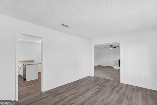 spare room featuring a textured ceiling, wood-type flooring, and ceiling fan