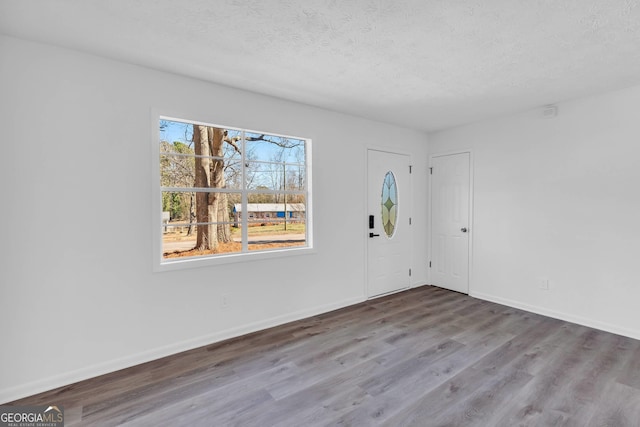 spare room featuring a textured ceiling and wood-type flooring