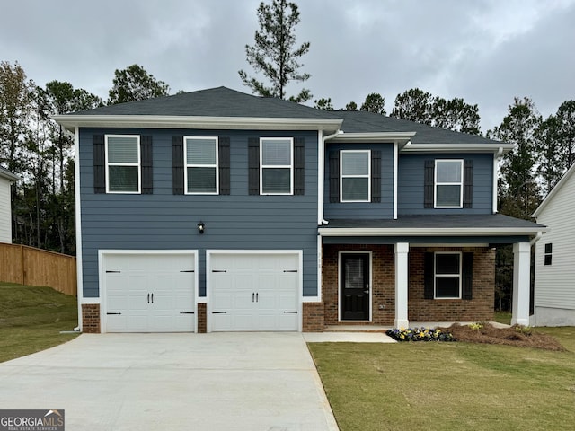 view of front of property with a front lawn, covered porch, and a garage