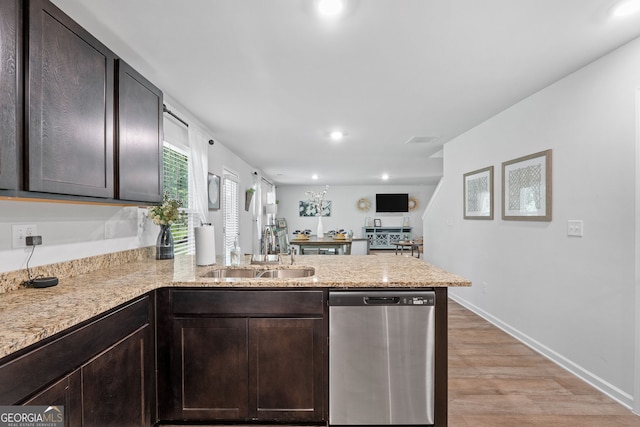 kitchen featuring sink, stainless steel dishwasher, kitchen peninsula, dark brown cabinets, and light wood-type flooring