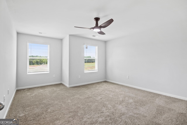 carpeted empty room with ceiling fan and a healthy amount of sunlight