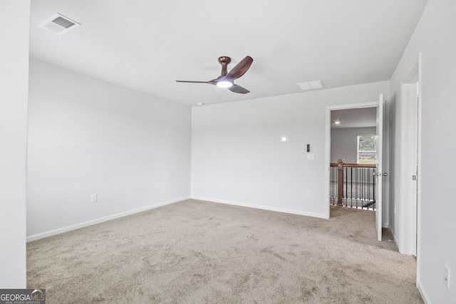 unfurnished room with light colored carpet and ceiling fan