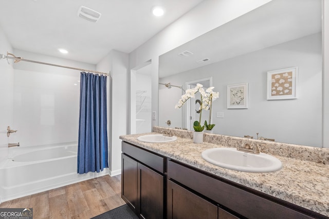 bathroom with hardwood / wood-style floors, shower / bath combo, and vanity