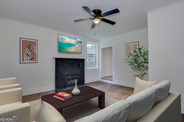 living room with crown molding, a fireplace, ceiling fan, and hardwood / wood-style floors