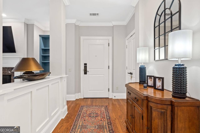 entryway with ornamental molding and light hardwood / wood-style flooring