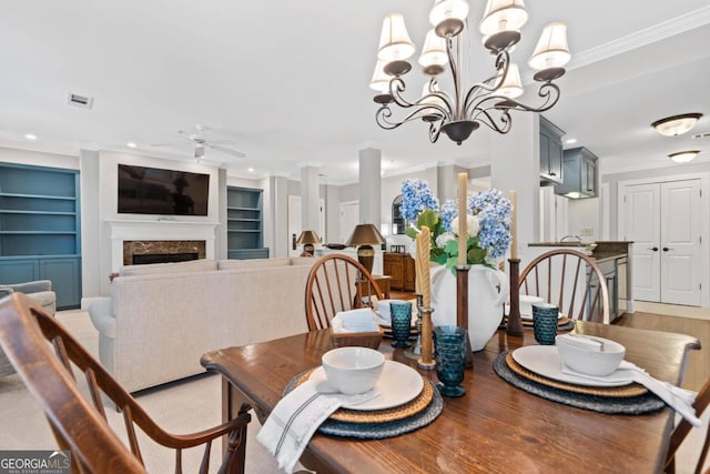 dining area featuring built in shelves, a fireplace, ornamental molding, and light wood-type flooring