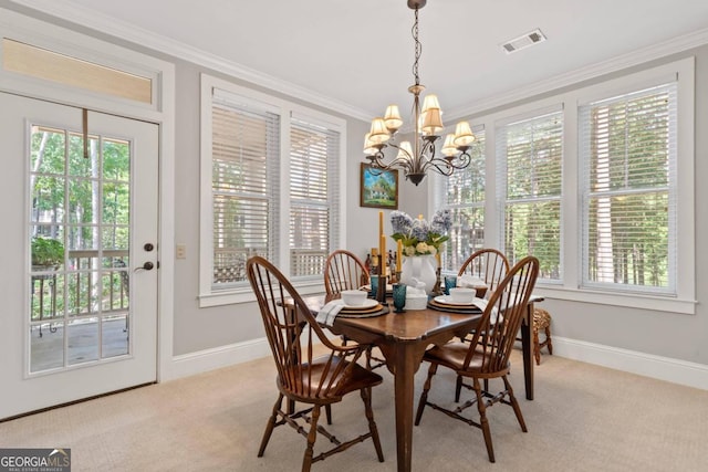 carpeted dining room with ornamental molding, a chandelier, and plenty of natural light