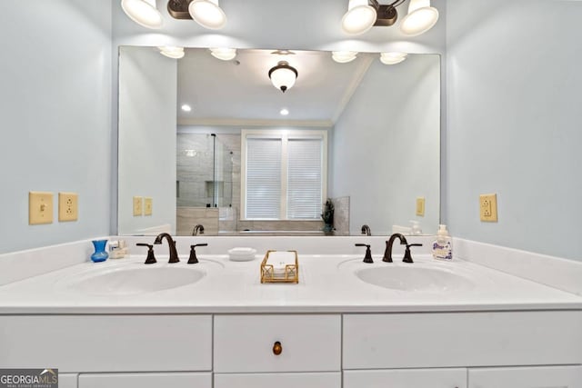 bathroom with ornamental molding, a shower with shower door, and vanity