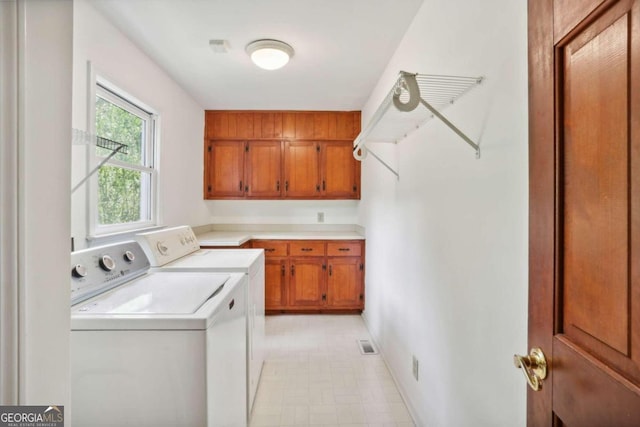 laundry room featuring cabinets and separate washer and dryer