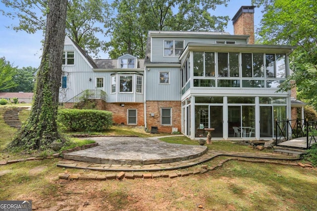 rear view of property featuring a sunroom and a patio