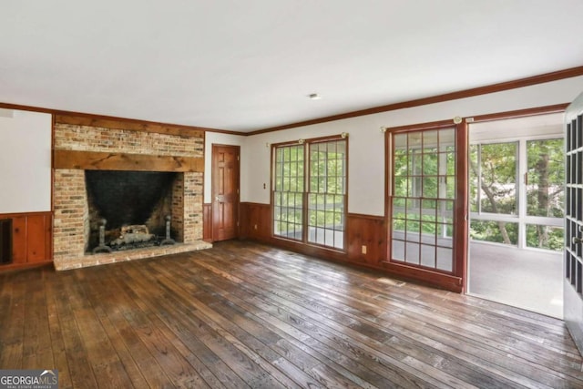 unfurnished living room featuring dark hardwood / wood-style floors, ornamental molding, and a fireplace