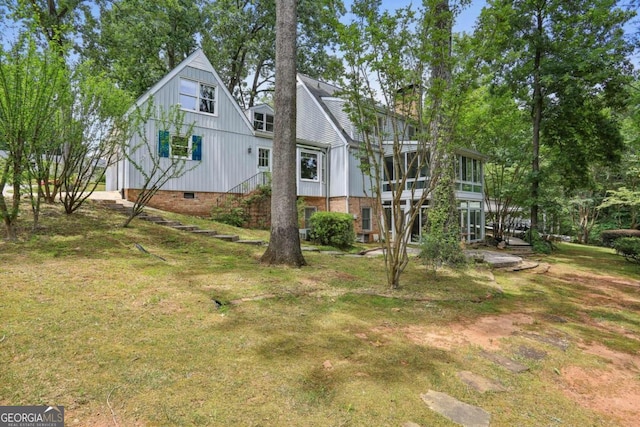 rear view of house with a lawn and a sunroom