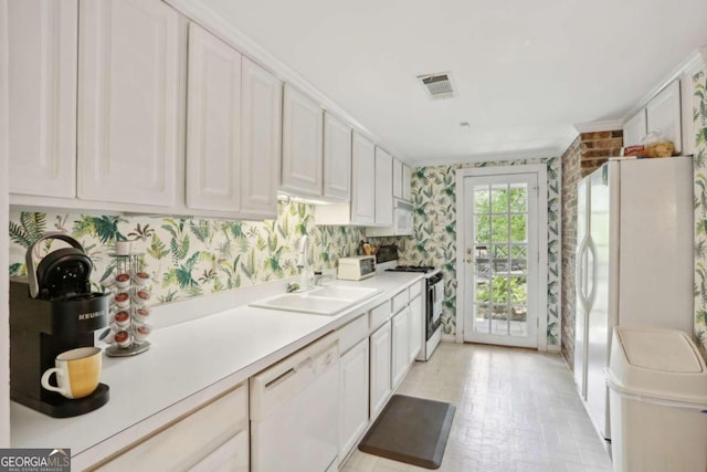 kitchen with white cabinetry, white appliances, and sink