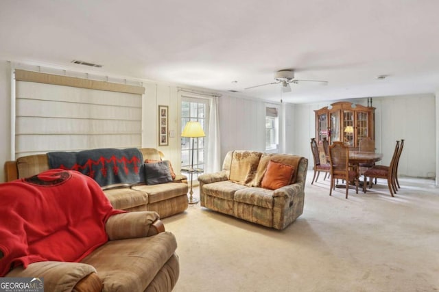 carpeted living room with ceiling fan