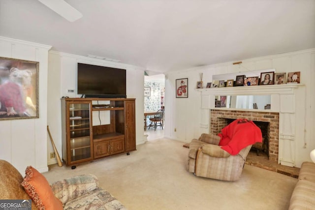 living room featuring crown molding, carpet, and a brick fireplace